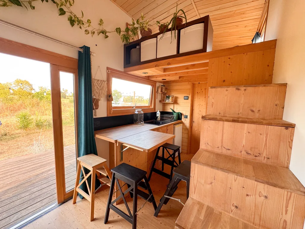 Cuisine et espace repas de la tiny house avec mezzanine