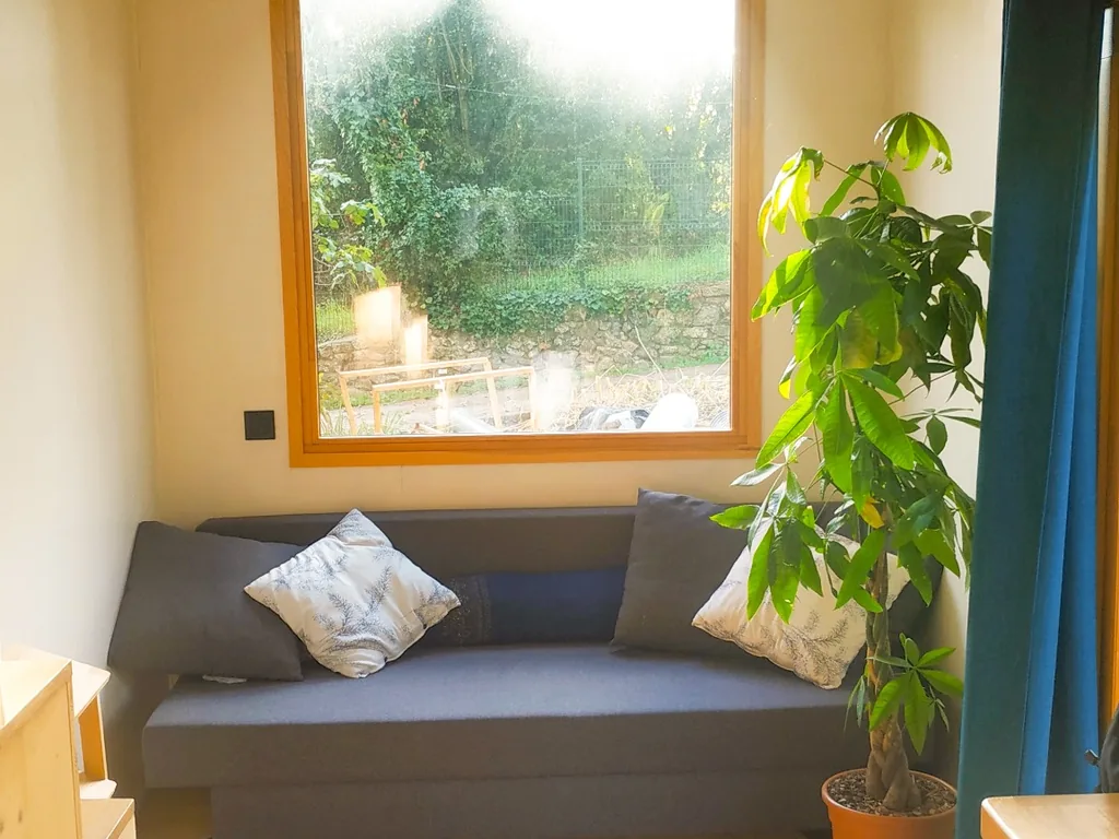 Salon lumineux de la tiny house avec vue sur la nature